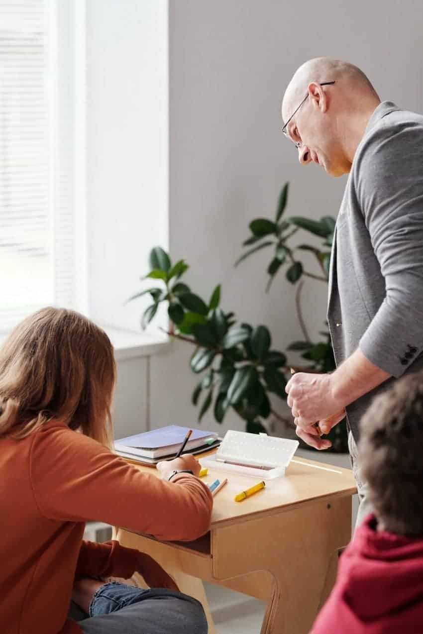 Teacher looking over student’s work to help learn