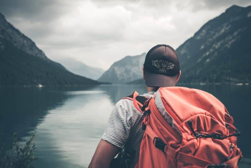 “University of the People student hiking with a red backpack”