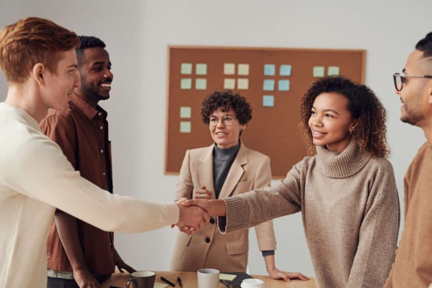 Multicultural group of workers shaking hands at a meeting