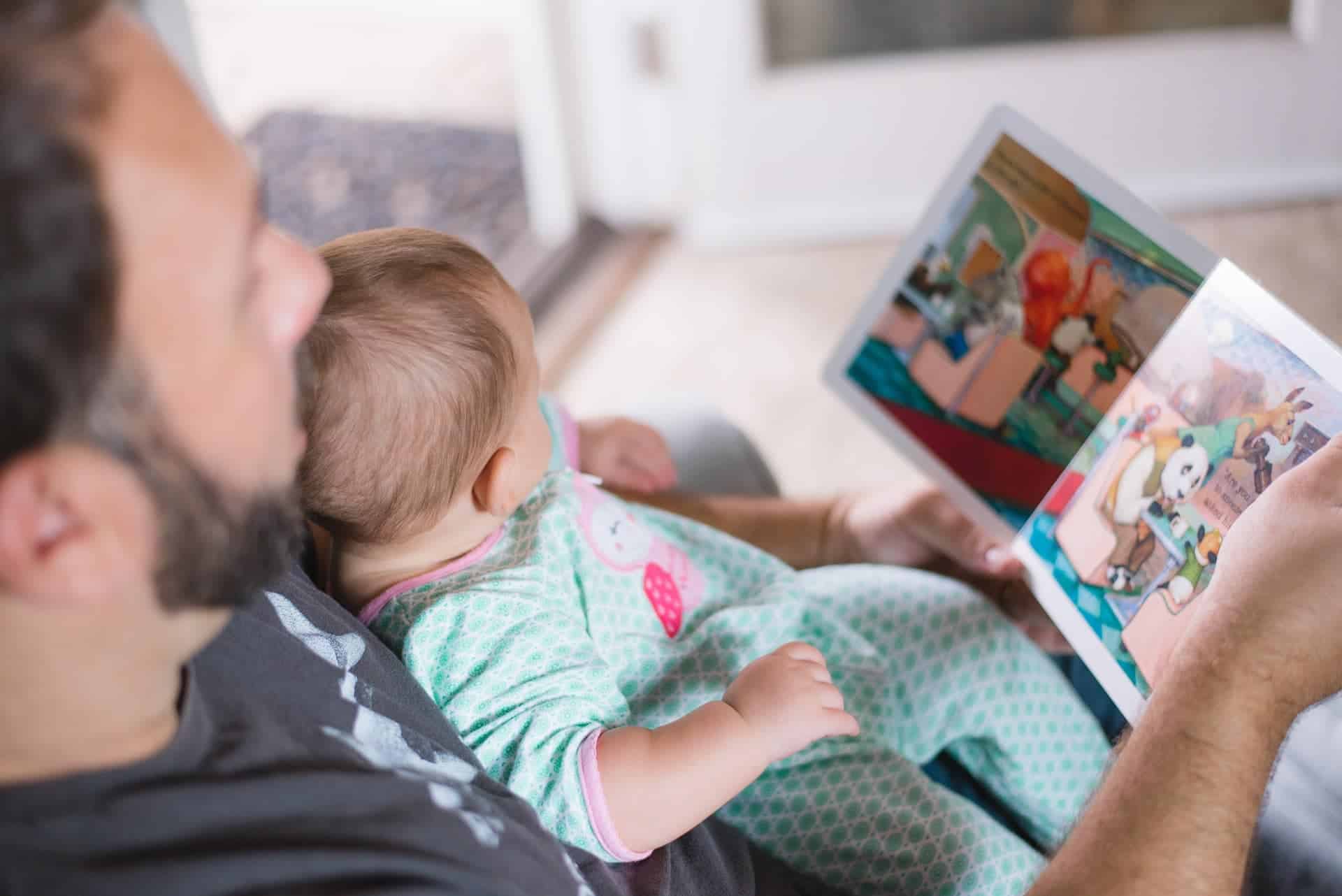 A father reading to their small child.