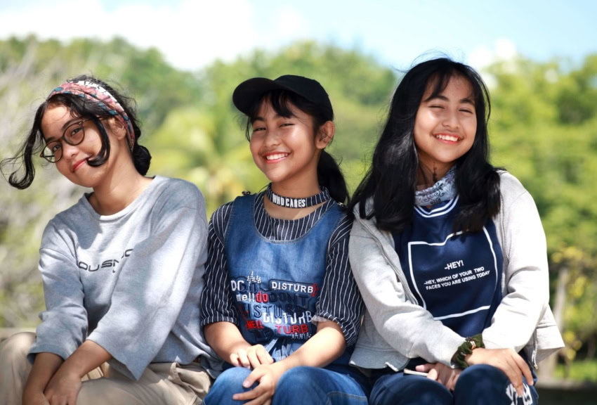 Three students sit together against bullying in schools