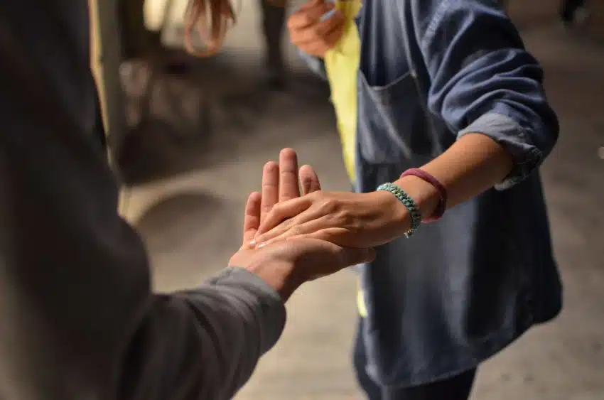 Friends with an outstretched hand offering support at UoPeople