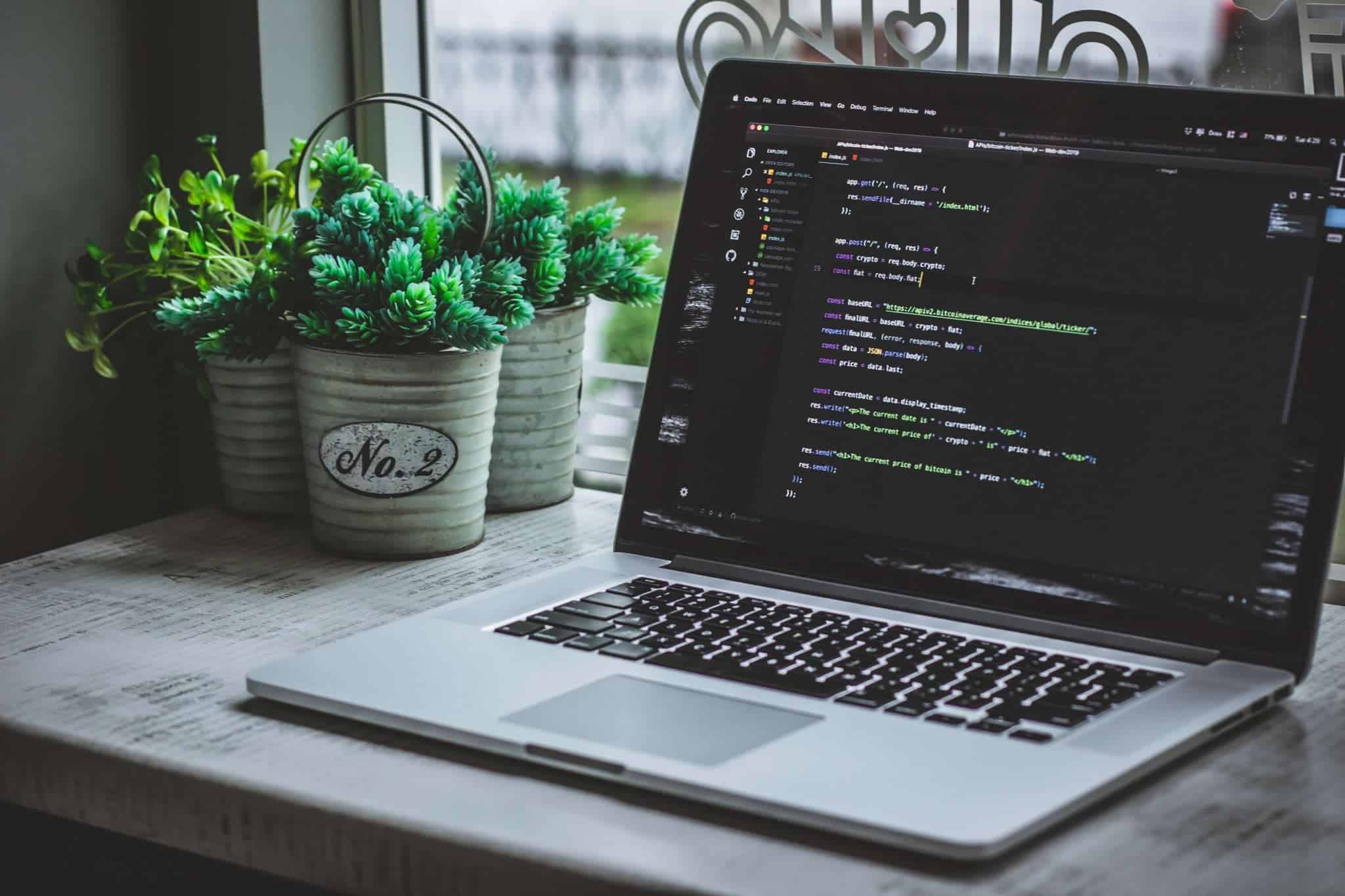 Open laptop on desk with code displayed