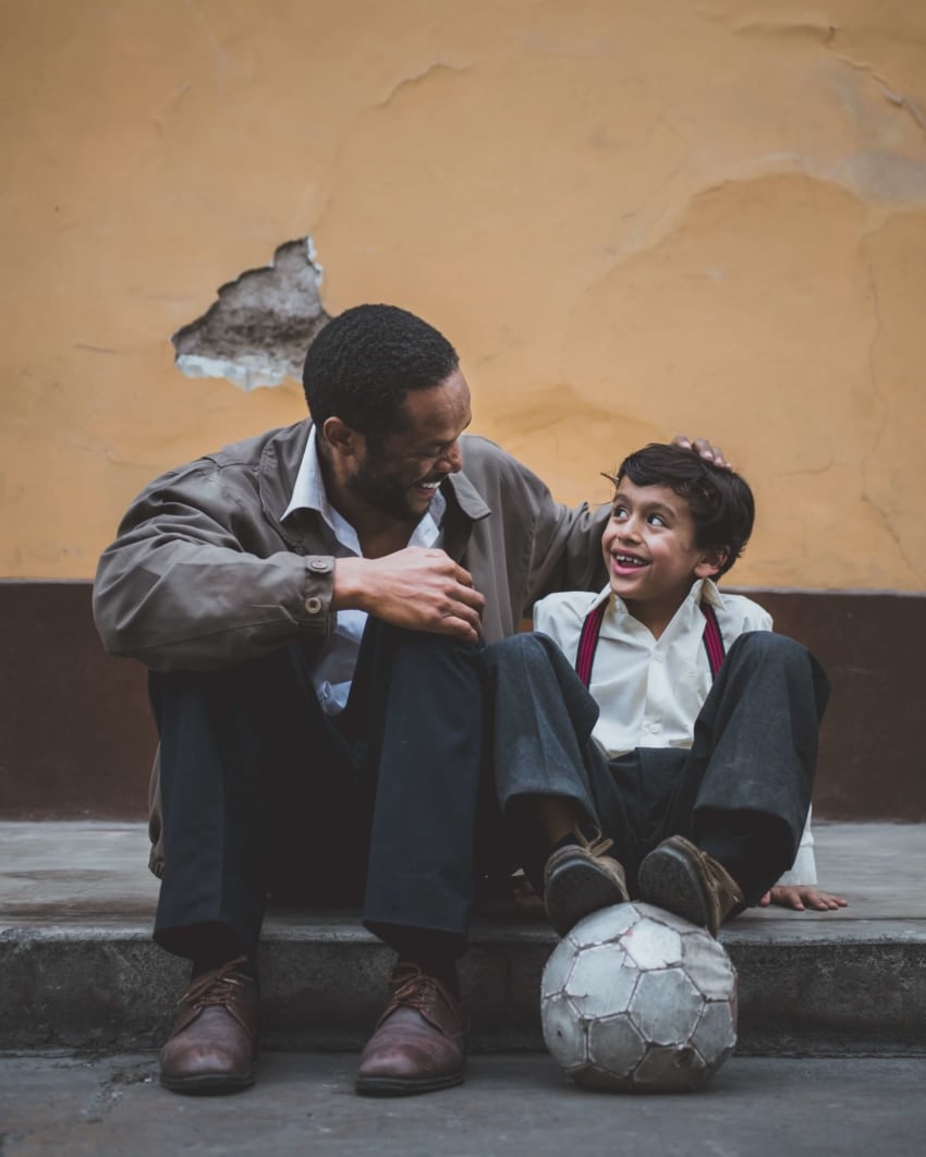 Teacher and student playing soccer and smiling