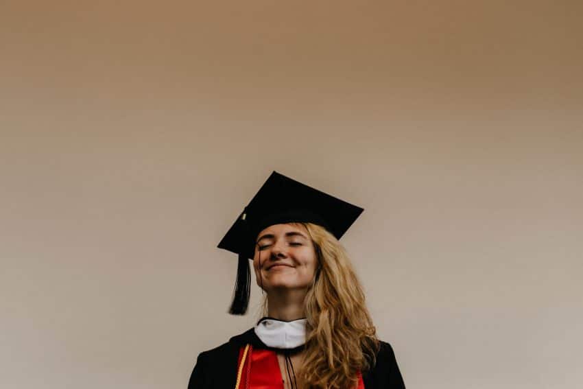 Female finance graduate in cap and gown