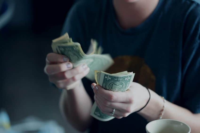 Person counting dollar bills in their hands