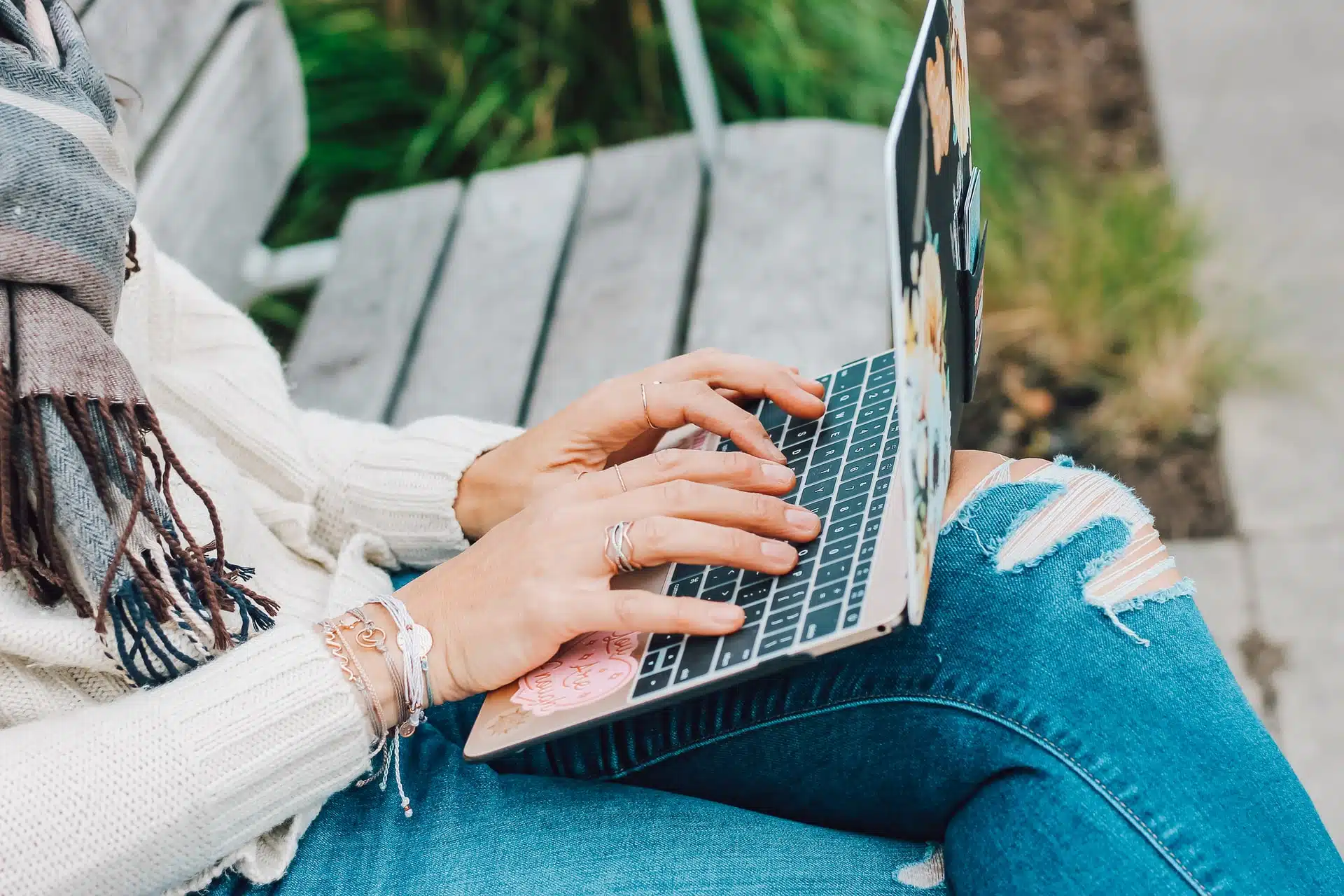 College student attending online college while sitting on a bench outside