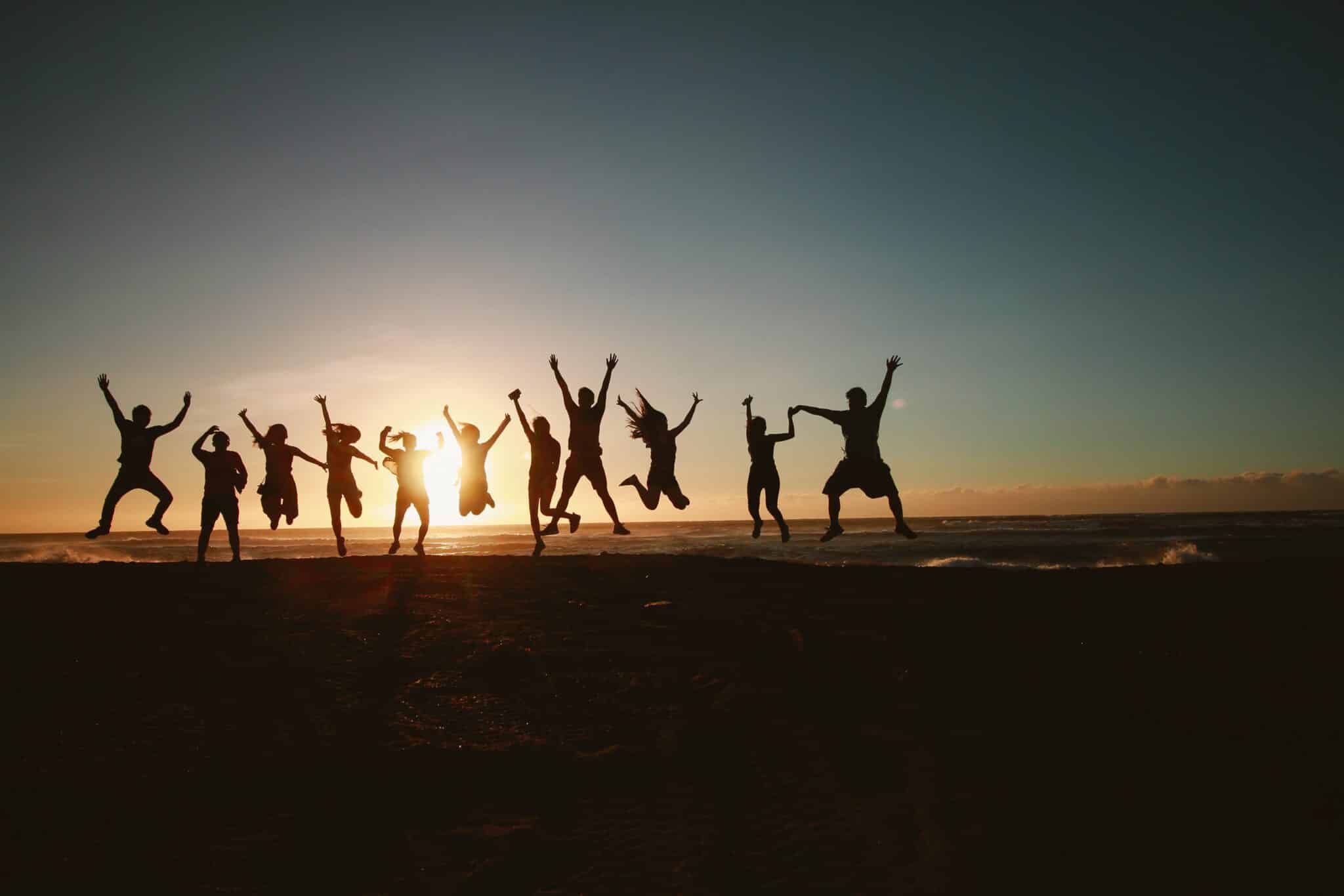 Students jumping joyously on a beach