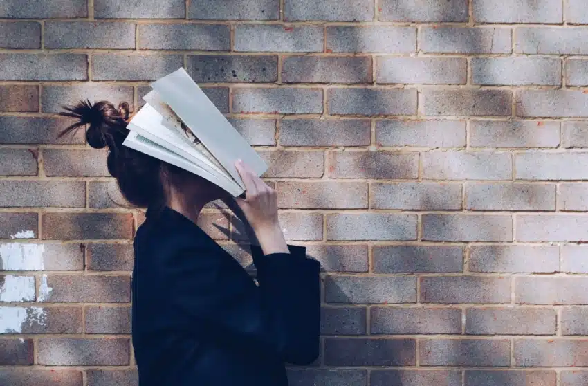 Student with book on her face