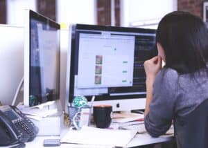 Marketing manager working at a large monitor.