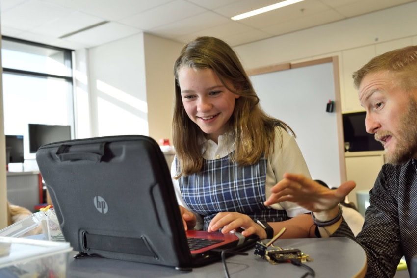 Teacher teaching student on computer