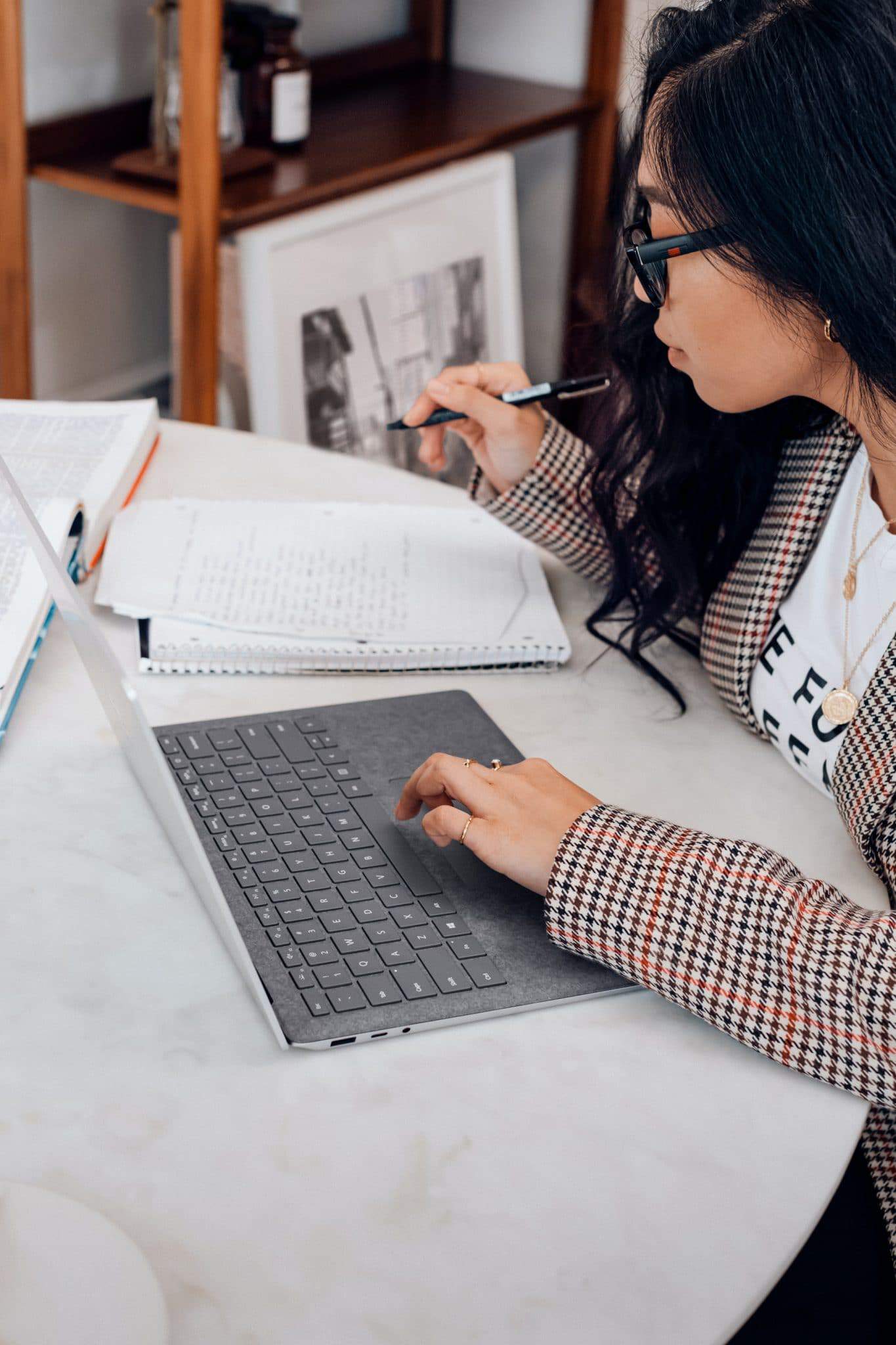 Student at a laptop taking notes to choose a major