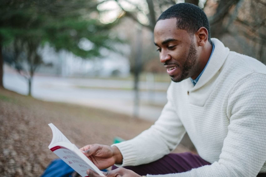 “University of the People student using reading techniques to read a book”