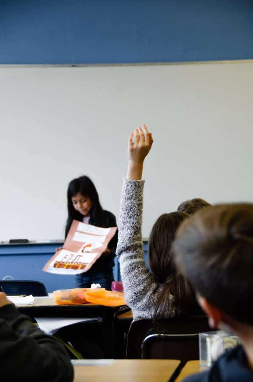 Student raising hand in a classroom