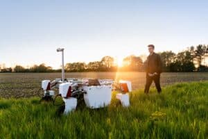 energy engineer standing in a field with agriculture robot