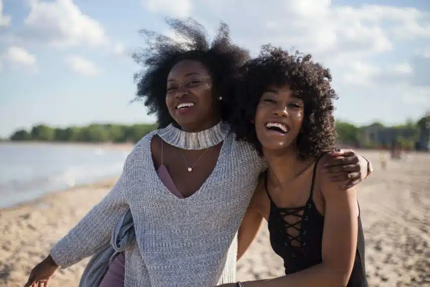 “Two female University of the People students smiling on a beach”