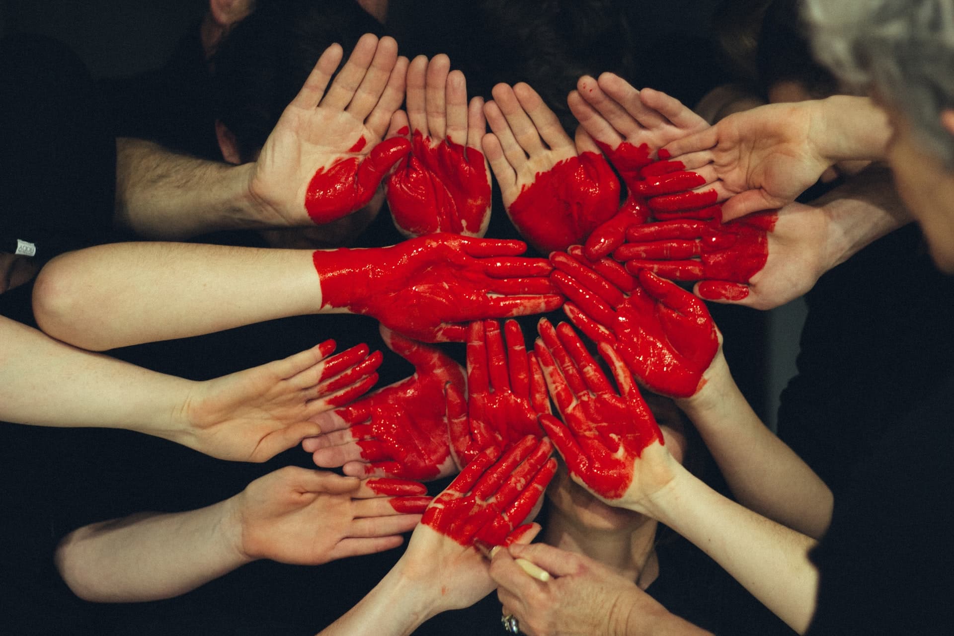 Group of hands with painted red heart