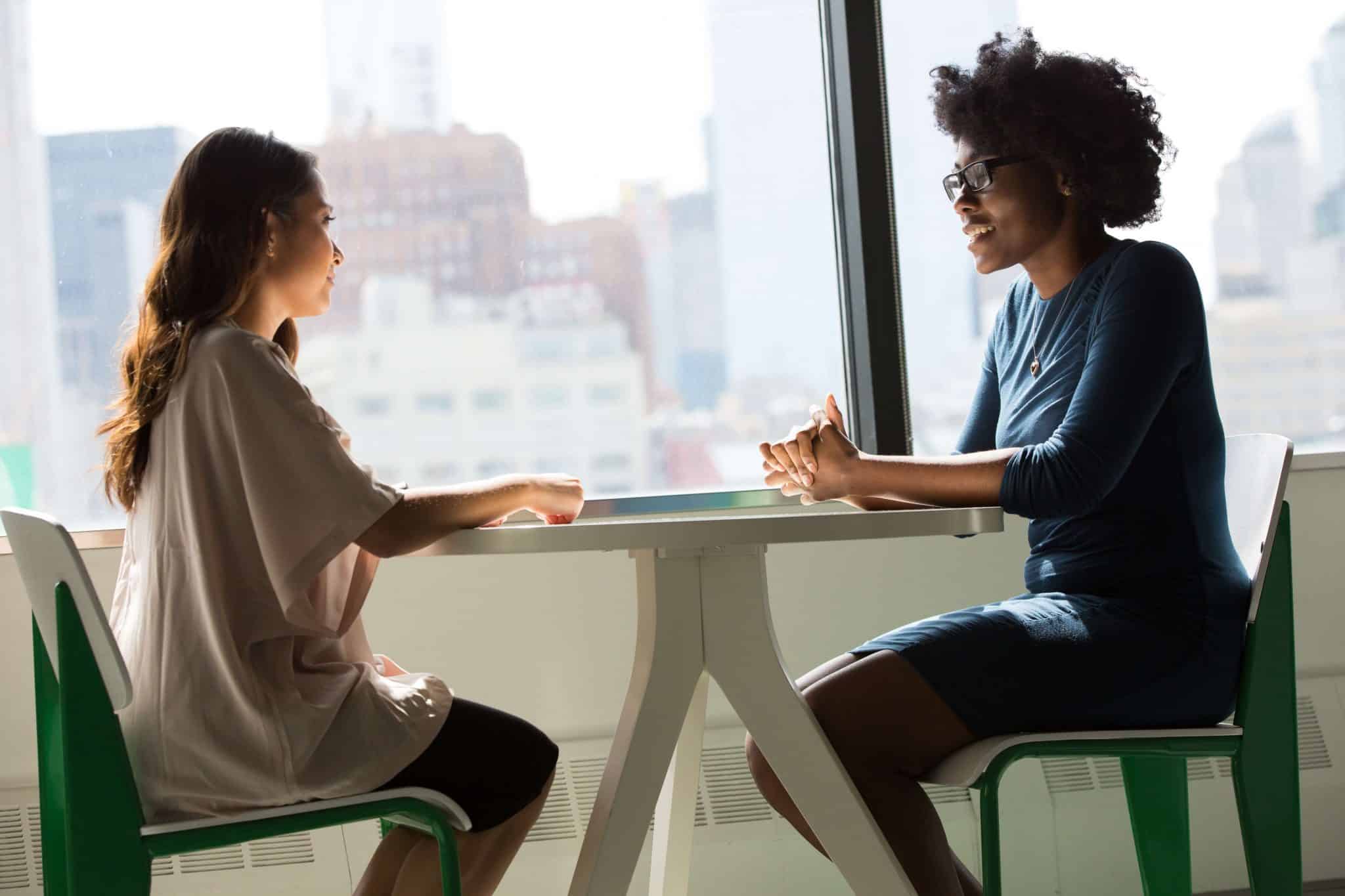 Two women communicating at a table