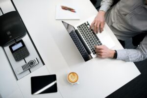 Finance student taking notes and studying on a computer