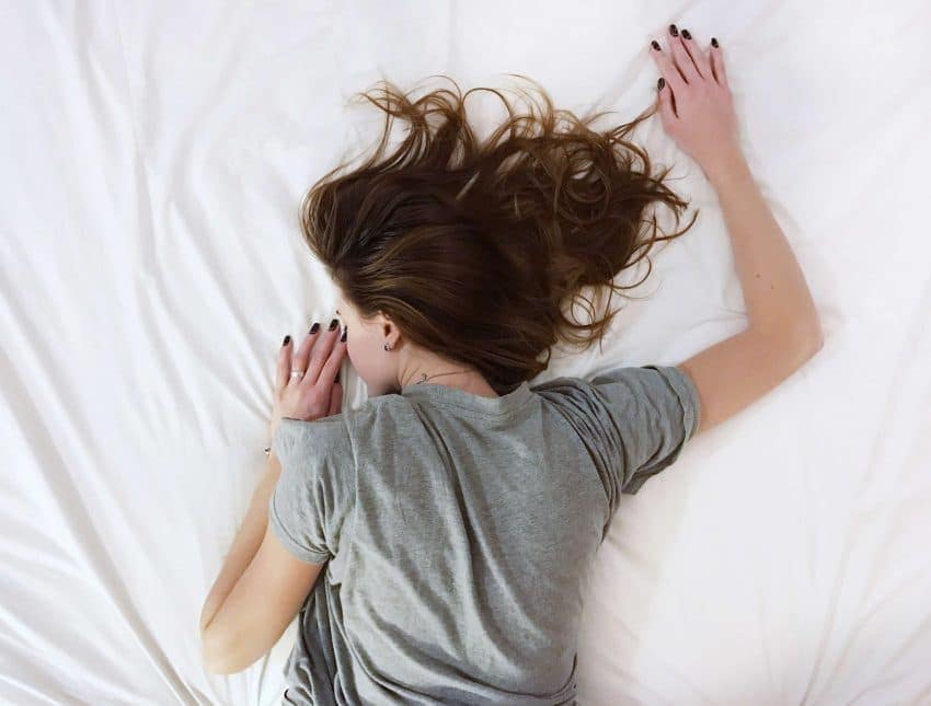 Tired high school senior laying down on the bed