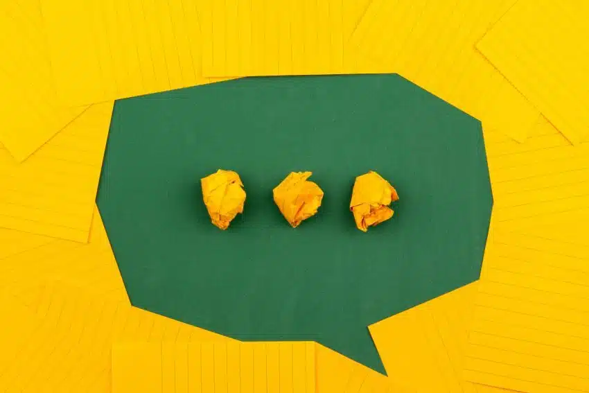 Thought bubble made of crumpled yellow papers on green background