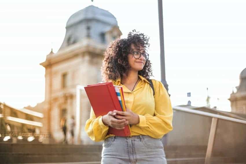 University of the People student holding study binder outdoors