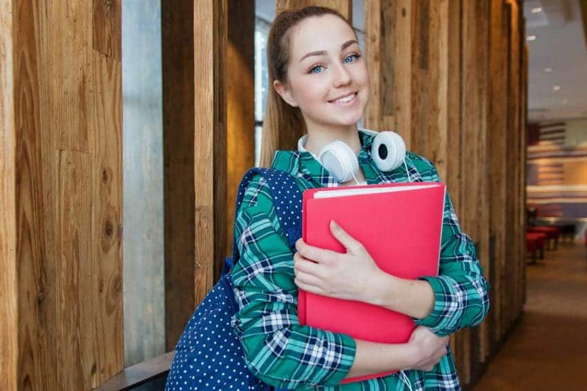 High school student in hallway with binder