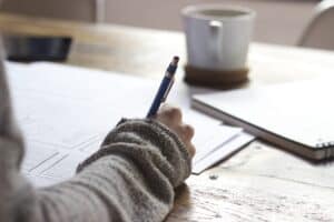 Woman at a desk writing. 