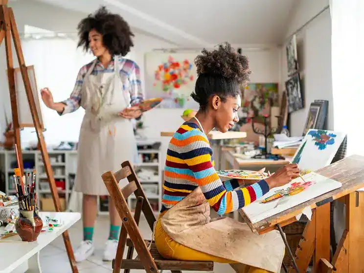 two female college students painting together