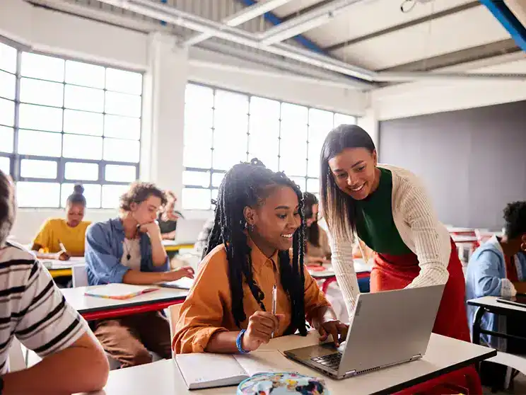 two female college students looking at a laptop