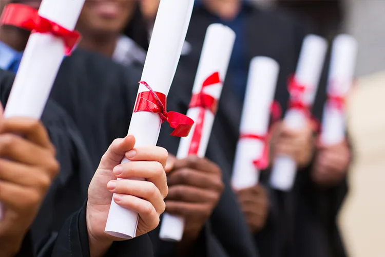 graduates holding their degrees in hands