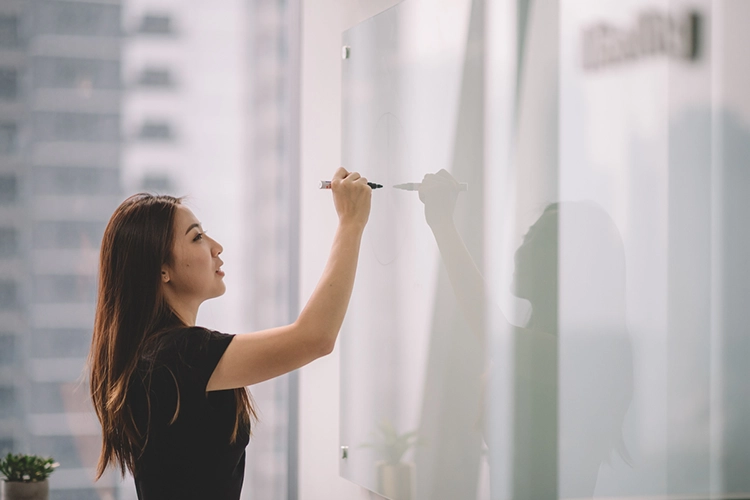 a female MSIT student writing on the white board