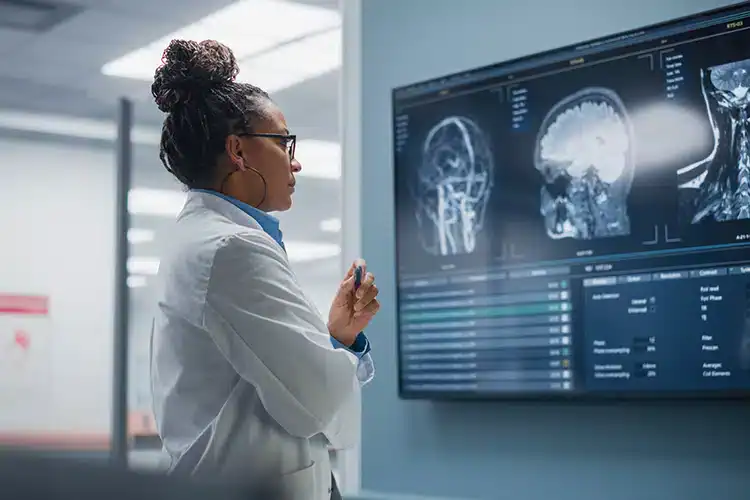 a female healthcare technologist assessing an image on the screen