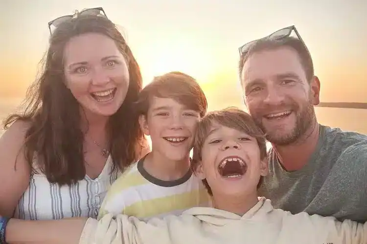 male M.Ed. graduate with his family
