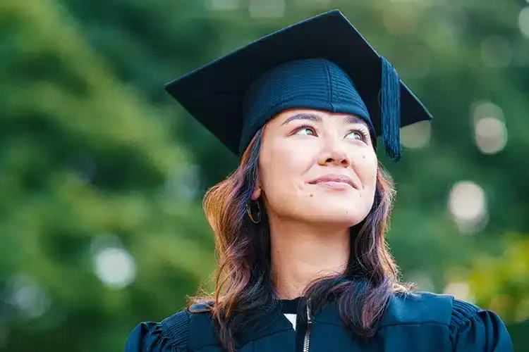 una orgullosa graduada universitaria posando para una foto el día de su graduación