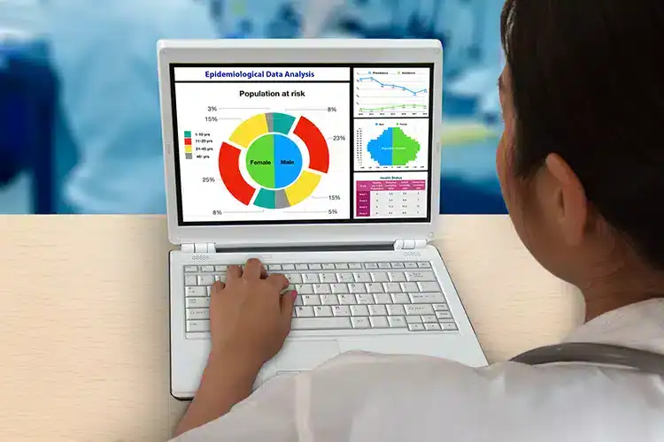 an epidemiologist assessing population disease stats on his computer
