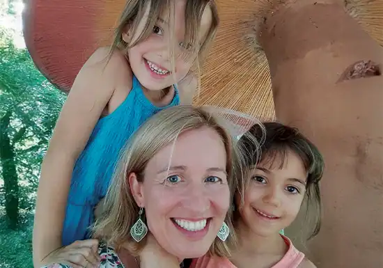 a female M.Ed. student of UoPeople posing with her children