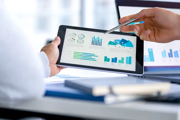 Person analyzes financial charts on a tablet with graphs and charts showing growth, suitable for Corporate Finance topics.