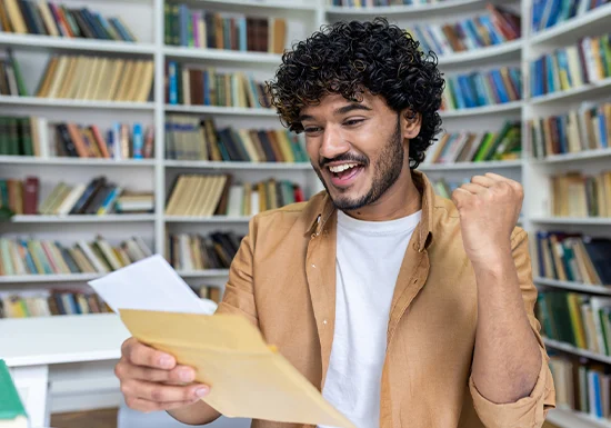 Webify Folder blog 17 Fellowship vs scholorship_Header a male college student excited at having received a scholarship